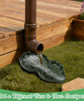 Dual Leaf Decorative Splash Block And Gutter Downspout Rain Diverter Extension For Lawn Patio Yard Garden Heavy Duty Weatherproof No Hassle Backyard Kickback To Shield Foundation Smooth Water Flow, brown downspout directing water onto green leaf-shaped splash block.