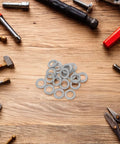 30 Pair M10 Double Layer Self Locking Wedge Shaped Anti Vibration Safety Washers Built From Heavy Manganese Steel on a workbench.