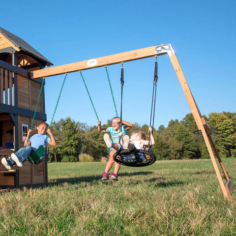Children playing on Cedar Wood Swing Set With Wave Slide And Elevated Clubhouse Play Kitchen And Picnic Area Belt And Web Swings