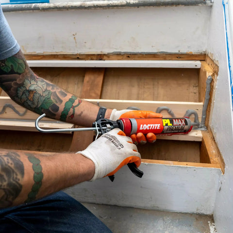 Person using Heavy Duty Construction Adhesive For Wood Concrete Stone And More Premium Max Strength Bond That Stays 100 Percent Solid After Curing In A 9 Oz Cartridge 1 Pack to reinforce a wooden staircase