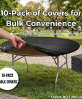 Person fitting a black plastic table cover on a 60-inch round table outdoors, stack of Ten Pack Black Round Plastic Table Covers For 60 Inch Tables Indoor Outdoor Fitted Covers 5 Feet Diameter Tables Not Included Bulk Party Catering Supply For Events Or Receptions visible