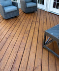 Heavy Duty Wood Stain And Sealer In One For Decks, 5 Gallon Semi Transparent Waterproof Coating In Light Walnut on a wooden deck with furniture.