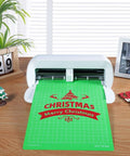 Front view: REALIKE 8.5x12 cutting mat, green with Christmas design, loaded in a white cutting machine.