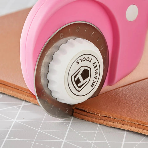 Close-up of 45mm Rotary Cutter Blades 10 Pack Compatible With Olfa And Fiskars Replacement cutting brown leather fabric.