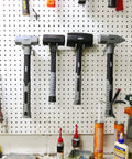 Six Piece Hammer Set For Metalworking: Forging, Pein, And Sledge Hammers displayed on a perforated tool board in a workshop