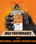 Pro Grade White Wood Filler That Kicks Out Nasty Cracks Holes And Gouges Water Resistant Paint Ready Acrylic Formula 6 Oz Tube in hand.
