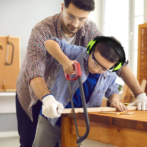 Child using a saw wearing Kids Noise Cancelling Ear Muffs 27NRR in green, adjustable ear protection for safe woodworking.