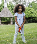 Child playing with Real Feel Toy Leaf Blower That Lights Up And Actually Blows Air, standing on grass, outdoor setting.
