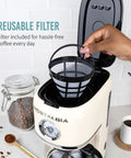 Classic Retro 10 Cup Drip Coffee Maker With One Touch Brew Reusable Filter Auto Shutoff Time Display Anti Drip Dishwasher Safe 50 Ounce Carafe Cream Finish Coffee Machine For Quick Mornings with reusable filter being placed inside.