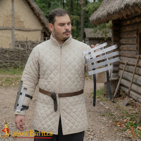 Man holding medieval bracers for cosplay and reenactments, fully functional arm guards with splinted steel, Viking inspired armor.