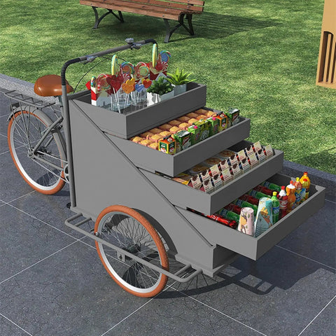 Slick Large Reverse Tricycle Vending Cart With Smooth Pedal Assist Front Loading Frame Four Tier Rollout Rack displaying snacks and beverages.