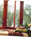 Cozy window seat with pillows and view of trees.