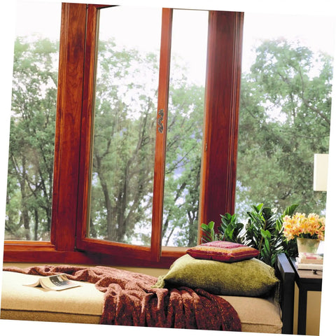 Cozy window seat with pillows and view of trees.