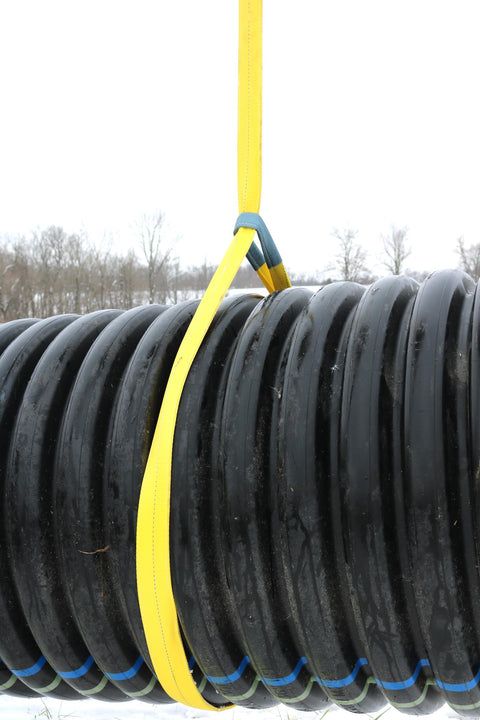 1 Inch by 4 Foot Flat Loop Eye to Eye Lifting Sling with Protective Sleeve in Yellow Polyester lifting black coil outdoors