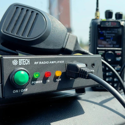 Close-up of UHF 400-480MHz Power Booster Amplifier for Handheld Radios 20-40W Extends Range and Clarity, in use with accessories.