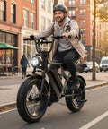 Man riding Fat Tire Electric Bike For Adults With 3000W Peak Motor 38 MPH Top Speed And 90 Mile Range on city street.