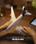 Hands assembling 1/280 Scale Lufthansa Airbus A380 Airplane Model Kit With Snap Fit Assembly, No Glue Needed, for desktop display.