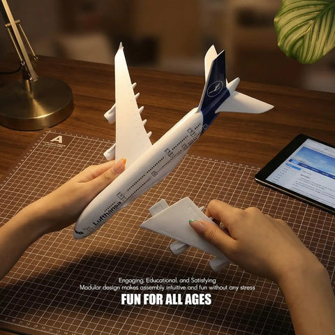 Hands assembling 1/280 Scale Lufthansa Airbus A380 Airplane Model Kit With Snap Fit Assembly, No Glue Needed, for desktop display.