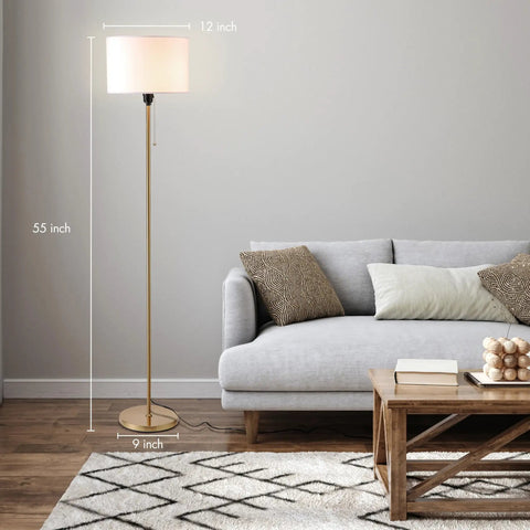 Drum Shade Standing Lamp With Pull Chain Switch, E26 Socket, Dope Modern Minimalist Floor Lamp In Antique Brass For Living Room, Bedroom, And Office, Concealed Cord From Base For Clean Look beside a sofa.