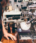 Person using Portable Espresso Scale With Timer For Coffee On The Go, showing 1000G Capacity, under espresso machine.