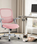 Ergonomic Mesh Office Chair For Home With Mid Back Support Rolling Swivel Desk Chair Lumbar Comfort Comfy Flip Up Arms Pink Ideal For Bedroom Study Student Use next to a desk with a cat on the floor.