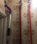 Mops hanging on Eight Piece Wall Mounted Mop Broom Holder Organizer Set With Stainless Steel Heavy Duty Racks in a floral wallpapered room.
