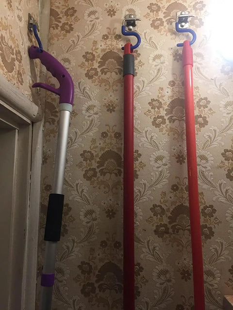 Mops hanging on Eight Piece Wall Mounted Mop Broom Holder Organizer Set With Stainless Steel Heavy Duty Racks in a floral wallpapered room.