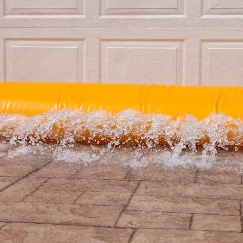 HydraBarrier Supreme Flood Barrier 12 Feet Long 20 Inches Wide 12 Inches High Water Diversion Tube in use at garage door