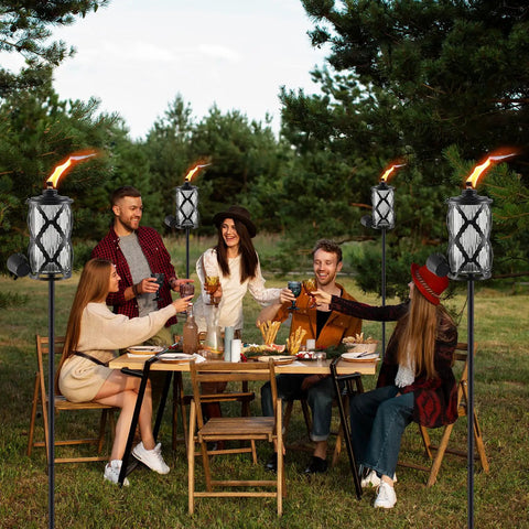 Group of people dining outdoors surrounded by 4 Pack Gray Glass Outdoor Garden Torches 59 Inch Tall With Upgraded 16 Oz Citronella Fuel