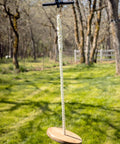 Zip Line Kit 150 Feet With Seat And Carabiner Heavy Duty One Quarter Inch Galvanized Cable Backyard Fun For Families Supports Up To 350 Lbs Weather Resistant Easy Setup For Hours Of Outdoor Adventure shown installed in a backyard with wooden seat and rope hanging low.