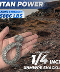 Hand holding UHMWPE D Ring Anchor Soft Shackle For Heavy Duty Marine Rigging And Recovery, rocky path background.
