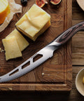 Five Inch Serrated Cheese Knife Crafted With Premium Steel Core And A Super Slick Hollow Blade For Butter Smooth Cuts That Slide Off Easy Plus A Gotta Have Fork Tip For Zero Mess Party Spread on a wooden cutting board with cheese.