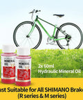 Brake Bleed Kit For Shimano Hydraulic Brakes With Mineral Oil 120ml, two bottles next to a green bike on grass