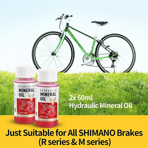 Brake Bleed Kit For Shimano Hydraulic Brakes With Mineral Oil 120ml, two bottles next to a green bike on grass