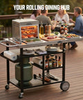 Stainless Steel Grill Cart And Pizza Oven Table With Wheels For Infrared Grills Universal Outdoor BBQ Station Built To Last Fits Ooni Ninja Gozney And More Sturdy Prep Surface With Ample Storage Shelf And Mobility on a deck with food and drinks.