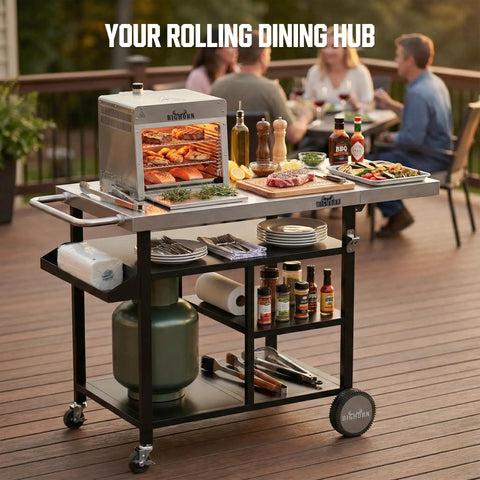 Stainless Steel Grill Cart And Pizza Oven Table With Wheels For Infrared Grills Universal Outdoor BBQ Station Built To Last Fits Ooni Ninja Gozney And More Sturdy Prep Surface With Ample Storage Shelf And Mobility on a deck with food and drinks.