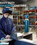 Worker in protective gear assembling heavy duty industrial casters in a workshop setting with equipment in the background.