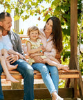 Family enjoying quality time on a wooden swing in a lush garden setting, representing outdoor lifestyle.
