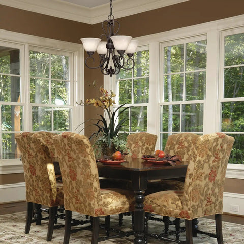 Rubbed Bronze Mini Chandelier With Warm Tea Stone Glass in a cozy transitional dining room over a rustic-modern table.