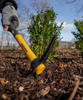 Micro Pick Mattock With Fiberglass Handle For Soft And Hard Ground in use, breaking soil in a garden setting