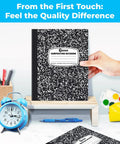 Hand holding one from 100 Pack Wide Ruled Composition Notebooks Bulk 200 Pages Each Hard Cover Black Marble Design