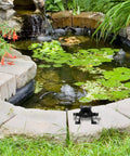 Compact Mini Self Priming Pump For Cordless Power Drills That Transfers Liquids Fast While Delivering A No Sweat Setup For Backyard Irrigation And Daily Home Tasks next to a pond with lily pads.