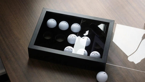 15 Ball Golf Ball Display Case Wooden Shadow Box With Acrylic UV Dust Cover on table, angled view, black interior, showcasing golf balls.