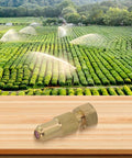 Image of High Pressure Adjustable Copper Spray Nozzle For Agricultural Sprayers Farm Ready Irrigation And Crop Protection One Point Five Hole Easy Turn Control Pro Grade Watering Solution in front of a lush green farm field with active irrigation.