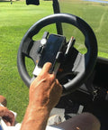 Hand using Golf Cart Steering Wheel Phone Holder With Flip Up Design And Scorecard Slot, 360 Degree Adjustable Anti Slip Smartphone Mount