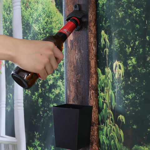 Heavy Duty Cast Iron Bottle Cap Opener Wall Mounted With Catcher Tray For Garage Bar Or Home Man Cave in use, bottle being opened.
