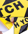 Close-up of Two Pack Watch Your Step Floor Stickers Anti Slip Safety Decal 6X24 Inch showing texture and peel-off backing.