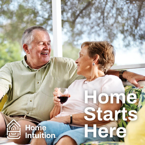 Older couple sitting on a patio, laughing, woman holding a glass, text reads 'Home Starts Here', 'Home Intuition' logo visible.