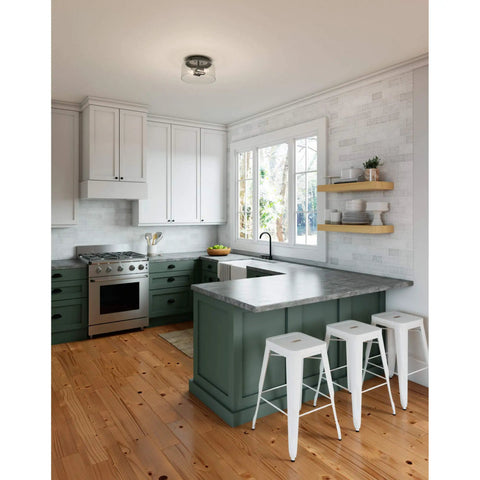 Modern kitchen with Hartland Flush Mount Ceiling Light in Noble Bronze With Seeded Glass Shade, white stools, and green cabinetry.