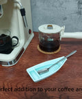 Boat Shaped Coffee Spoon Rest With Turquoise Accent And Matching Mini Spoon beside coffee maker on counter